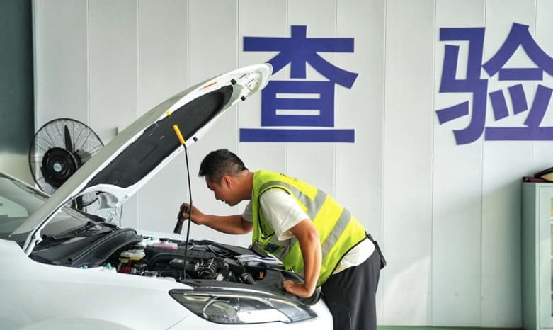 Technician reviewing a vehicle in an inspection bay
